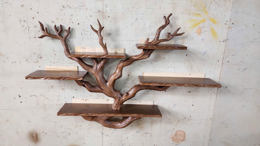 Handmade solid wood wall tree bookshelf with carved branches and floating shelves hung on a wall