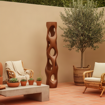 Ambera carved wood floor lamp in Brown finish with organic oval cut-outs, styled on a sunny terracotta patio