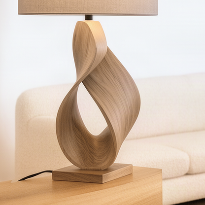 Close-up of the Infinia Natural lamp base showing the twisting ribbon curve, square plinth and wood grain