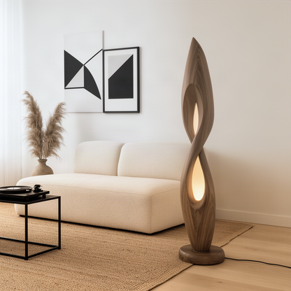 Flamara sculptural wood floor lamp in natural wood with twisting flame shape and warm glowing openings by a sofa
