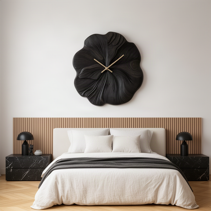Petalune sculptural wood wall clock in black with gold hands above a bed with marble nightstands