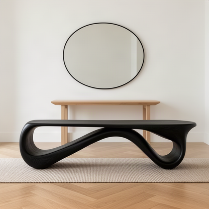 Loopara sculptural wood bench in black with flowing loops in an entryway below an oval mirror