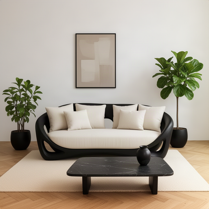 Cocoona sculptural wood sofa in black with cream cushions in front of a dark stone coffee table