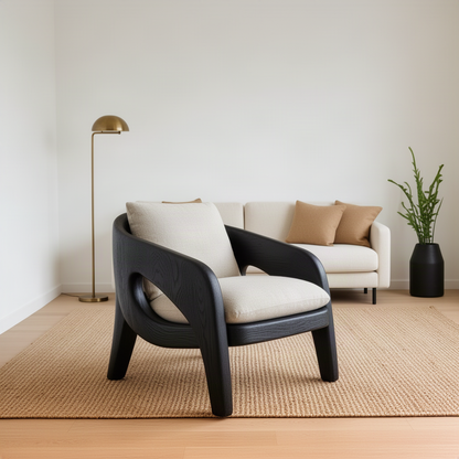Arcwell sculptural wood lounge chair in black finish, modern curved armchair with cream cushions in a minimal room