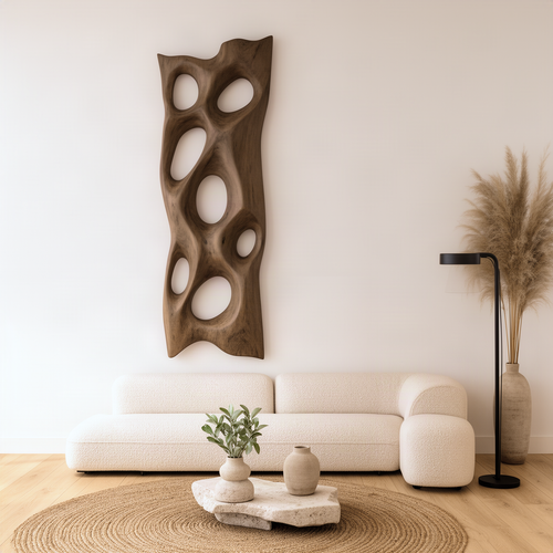 Porella sculptural wood wall art in natural finish, tall free-form panel with pierced oval openings above a sofa