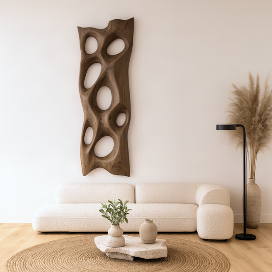 Porella sculptural wood wall art in natural finish, tall free-form panel with pierced oval openings above a sofa