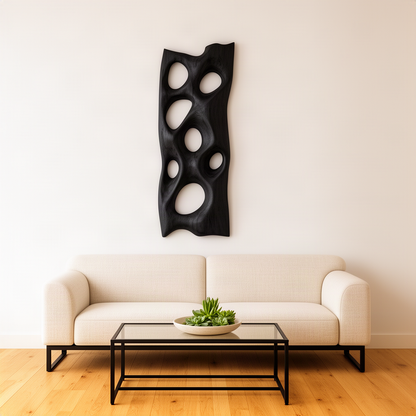 Porella sculptural wood wall art in black finish, modern pierced oval relief panel above a cream living room sofa